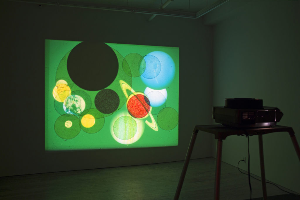 Slide installation by Jeanne Liotta, planets in green universe