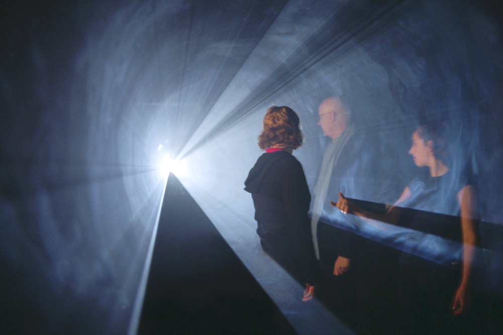 A film installation by Anthony McCall, viewers inside a cone of light